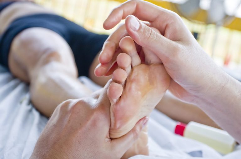 Sports massage therapist working on a client's foot – mobile sports massage, Milton Keynes